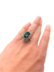 Green tourmaline surrounded by diamonds in starburst ring