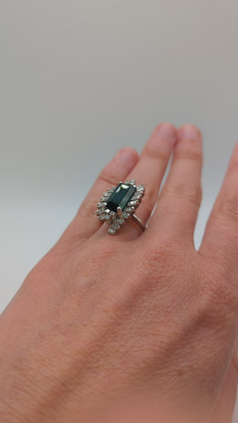 Green tourmaline surrounded by diamonds in starburst ring