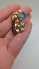 Blue zircon Retro brooch with swirling  rubies and diamonds